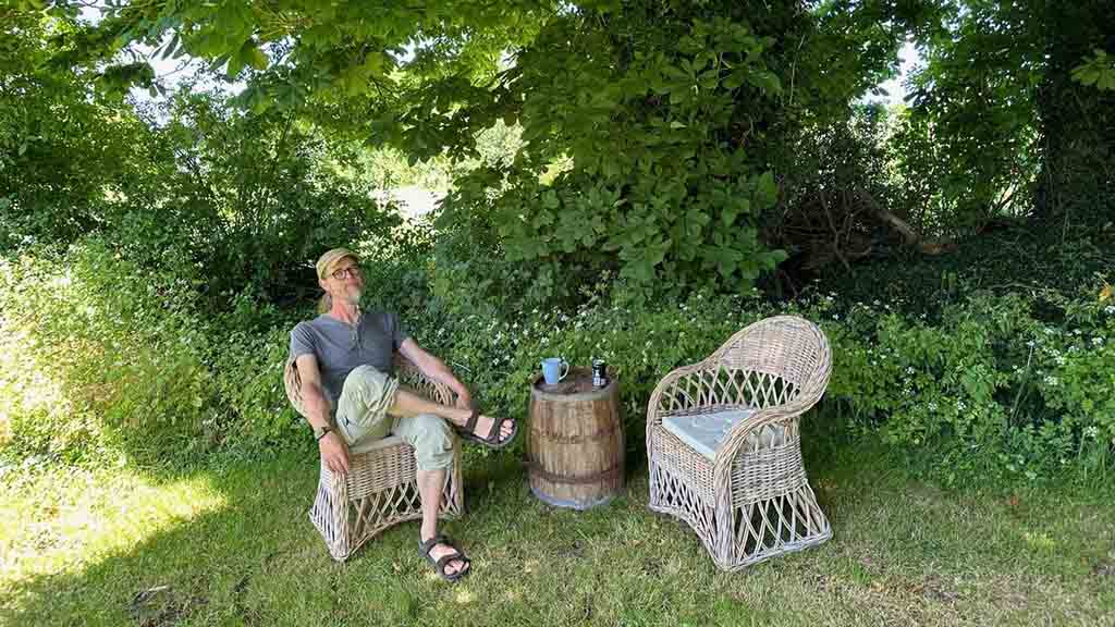 man sitting in garden furniture in the garden at Æbelø Nature Therapy