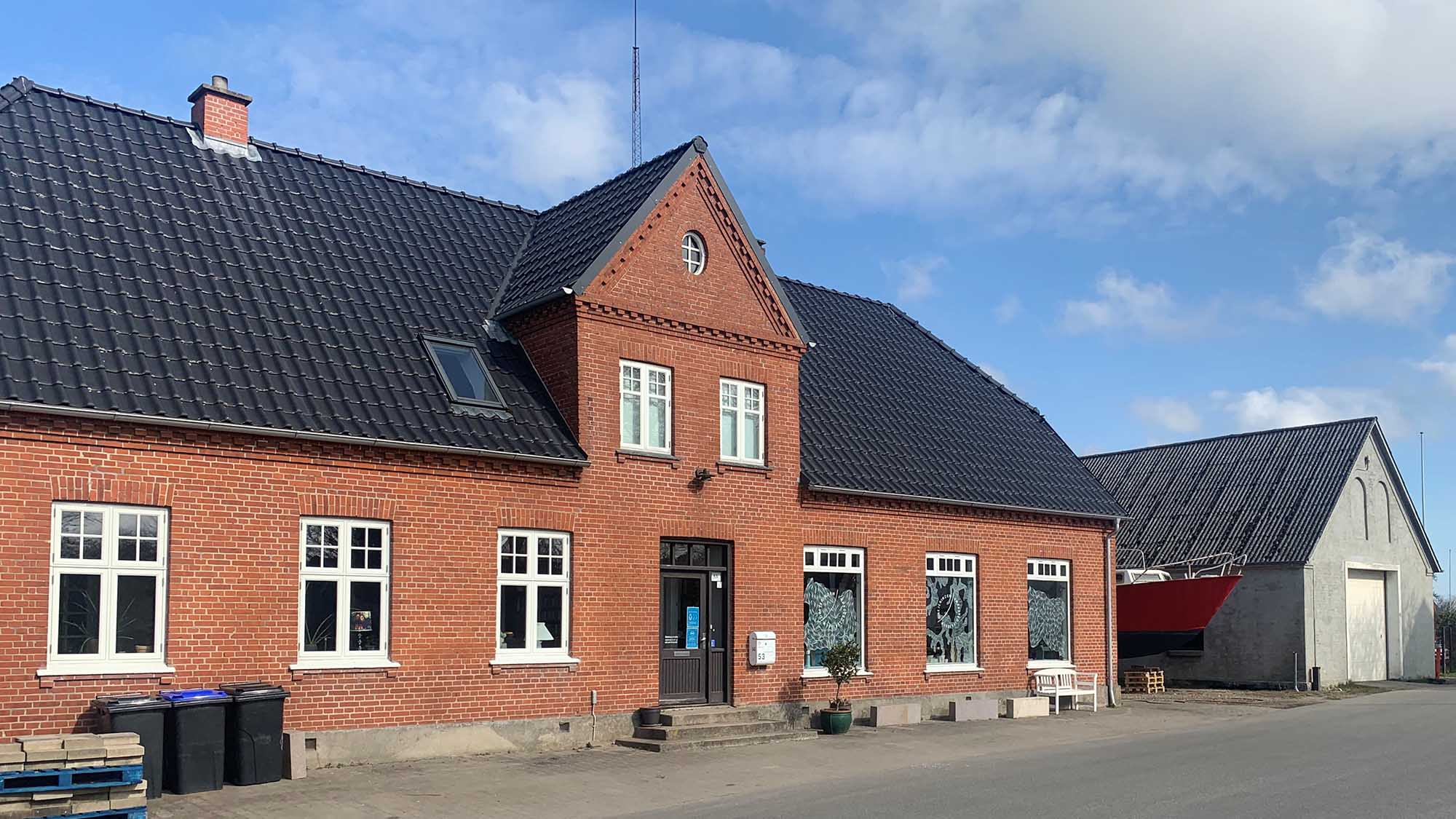 The façade of the Drejerinden gallery and the workshop chimney sweep in Ejlby