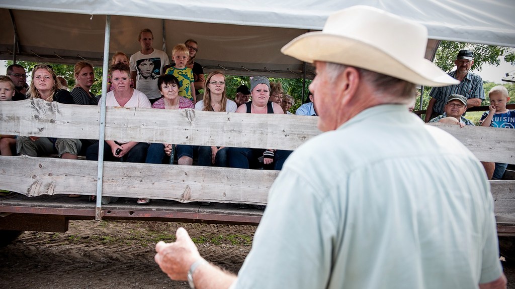Ein Guide erzählt den Gästen im Präriewagen vor der Tour zwischen den Bisons auf der Ditlevsdal Bisonfarm.