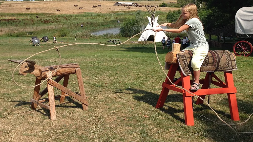 Girl catches a wooden bison with a lasso