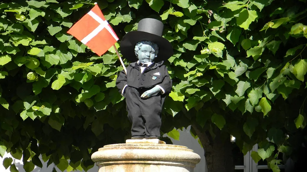 Manneken Pis in a suit and top hat and with the Danish flag