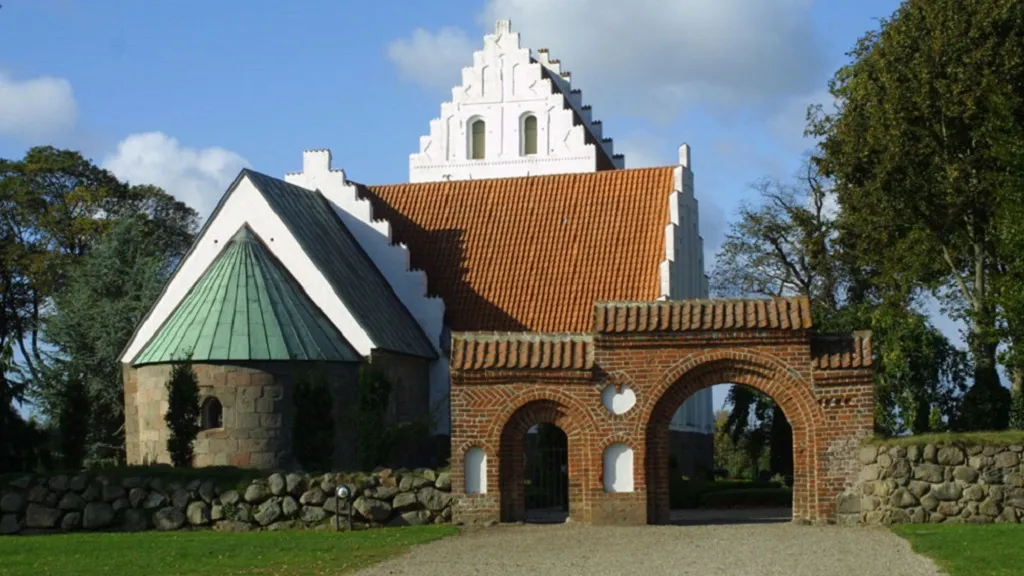 Skovby Church and the large church gate by the cemetery wall