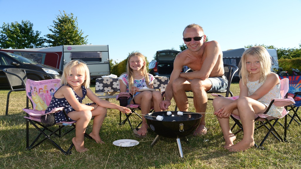 The family grills marshmallows at the First Camp Hasmark campsite on North Funen