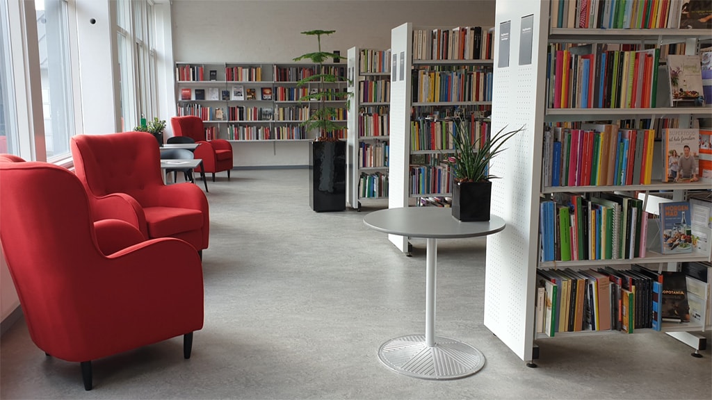 Ølgod Bibliotek set indefra med bogreoler og to røde lænestole