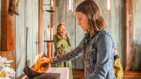 Pige tænder et lys i kirken på Bork Vikingehavn