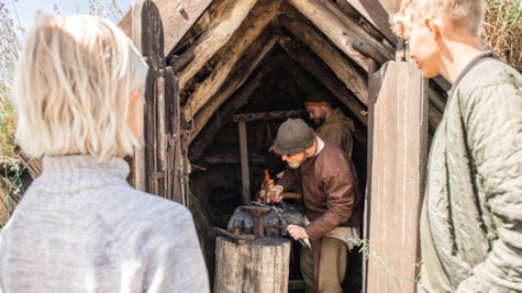 Gæster ser viking lave smedearbejde på Bork Vikingehavn