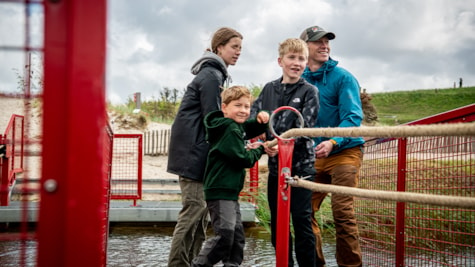 Familie trækker sig selv over vandet på trækfærgen i Naturkraft