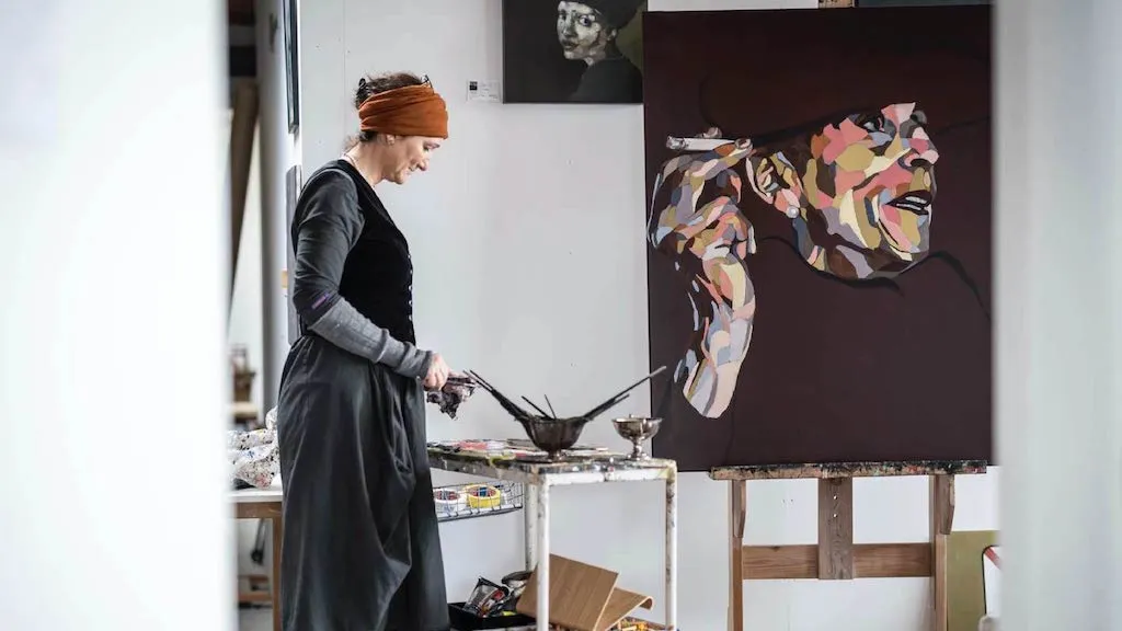 Agnete Brinch står og maler i sit atelier