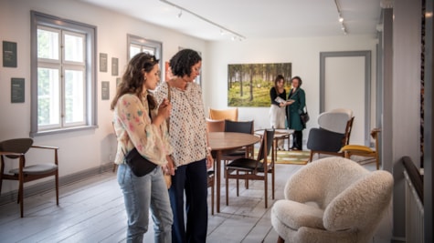 To kvinder ser på møbler i udstilling på Ringkøbing Museum