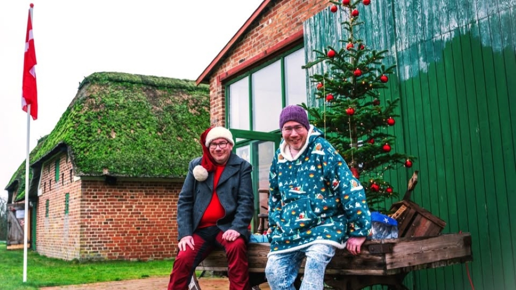 2 mænd sidder foran Gåsemandens Gård