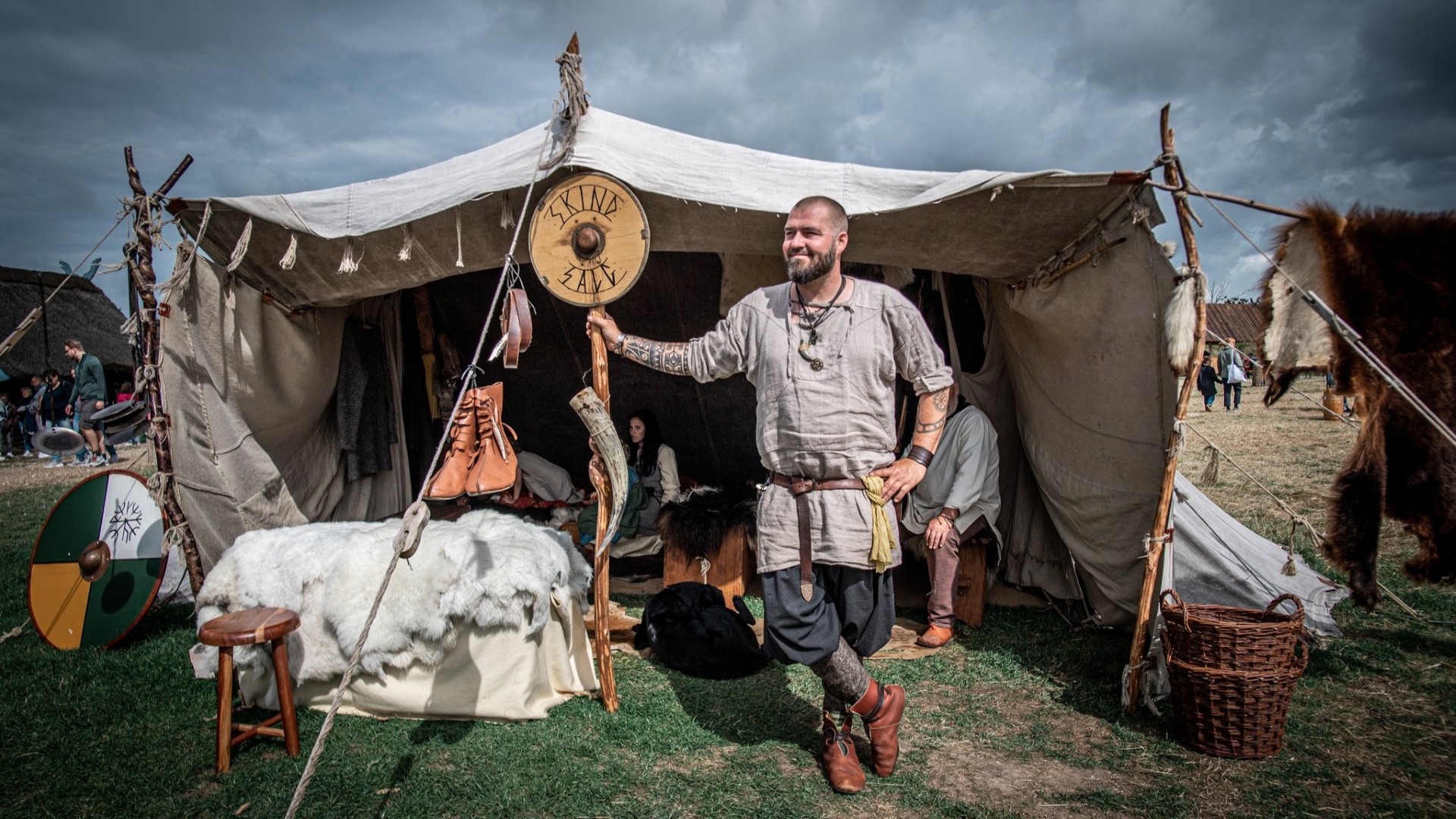 Wikinger in einem historischen Lager vor einem Marktzelt