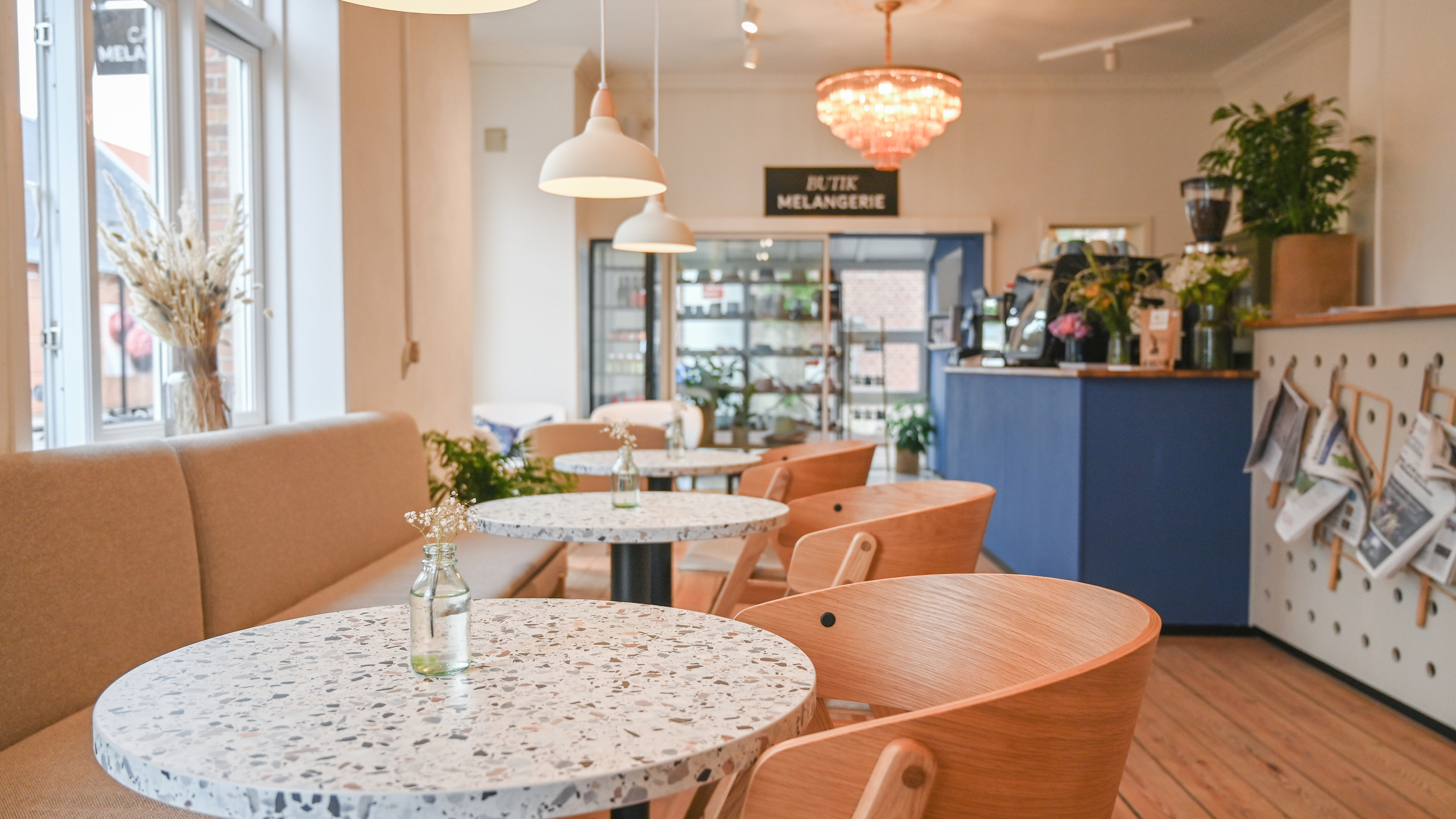 A cosily furnished venue with chairs, comfortable benches and tables.