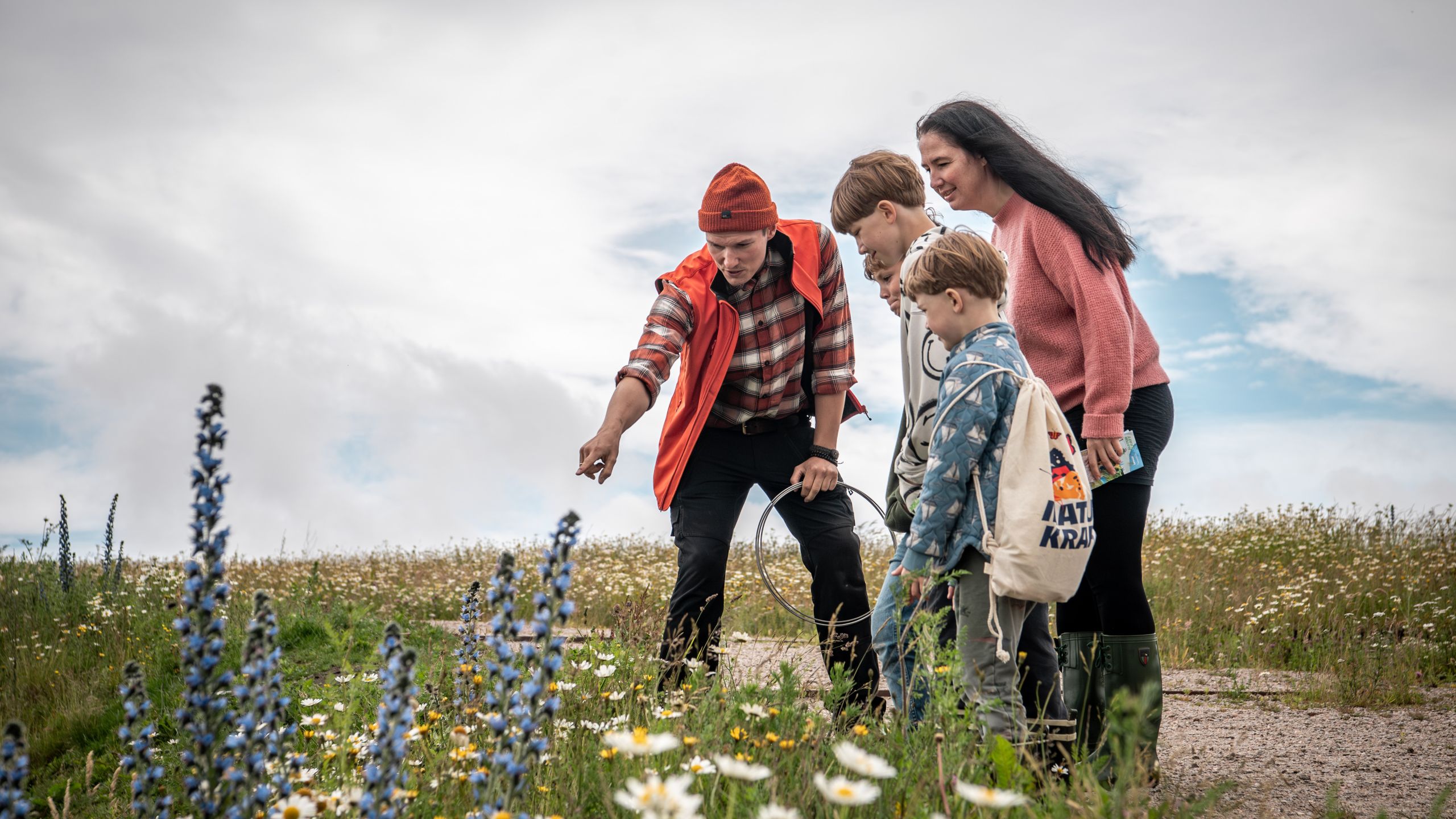 Familie udforsker planter sammen med en formidler