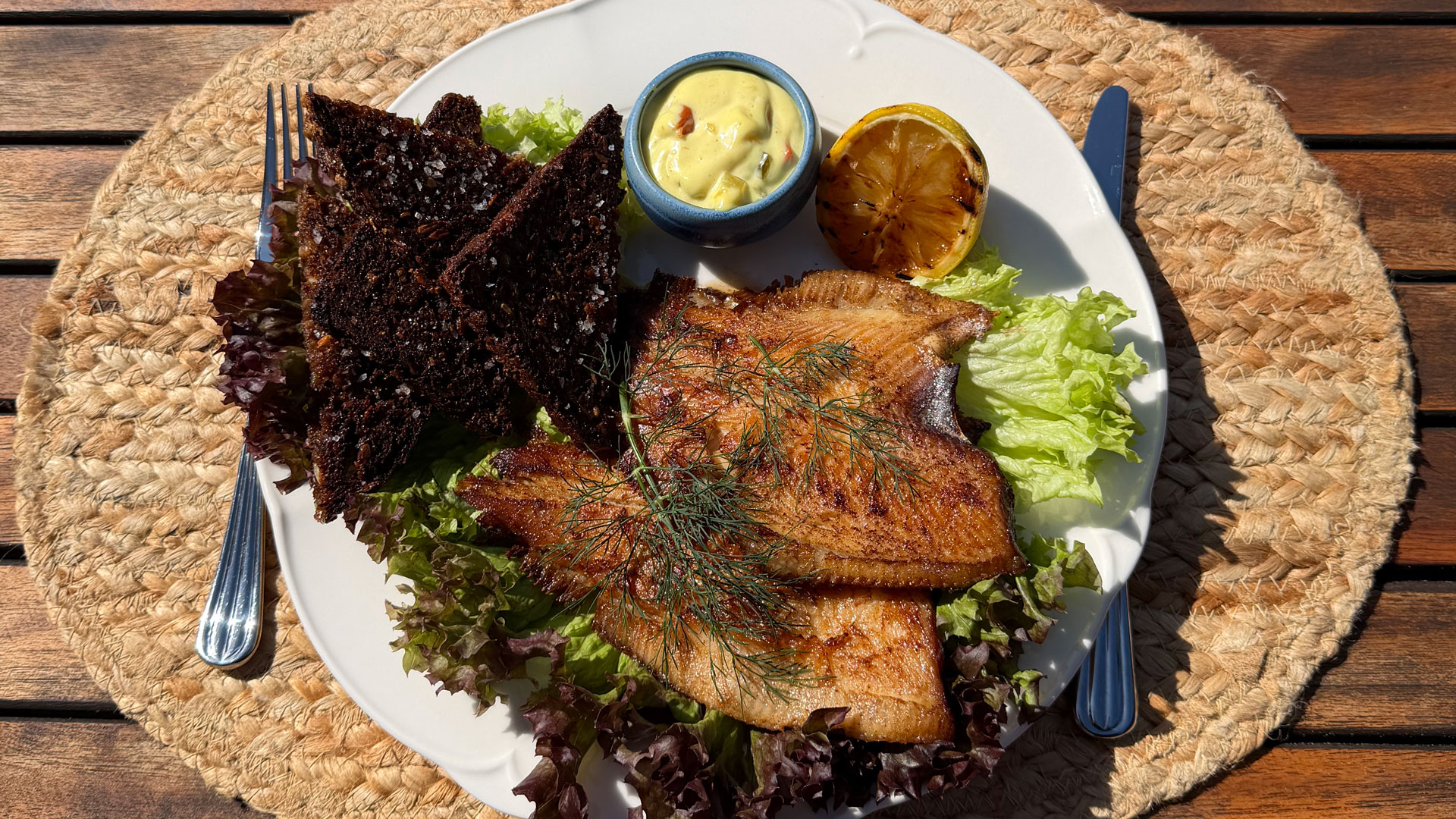 Fried dried plaice with rye bread, salad and remoulade.