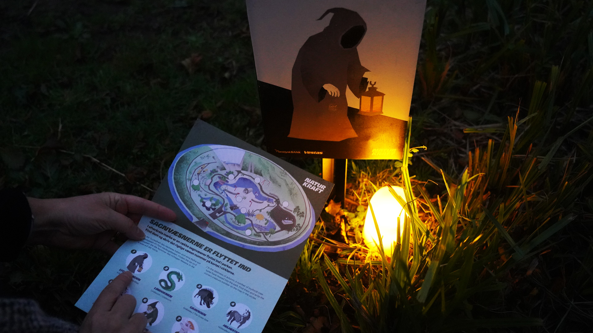 A visitor searching for legendary creatures at Naturkraft using a map and lanterns.