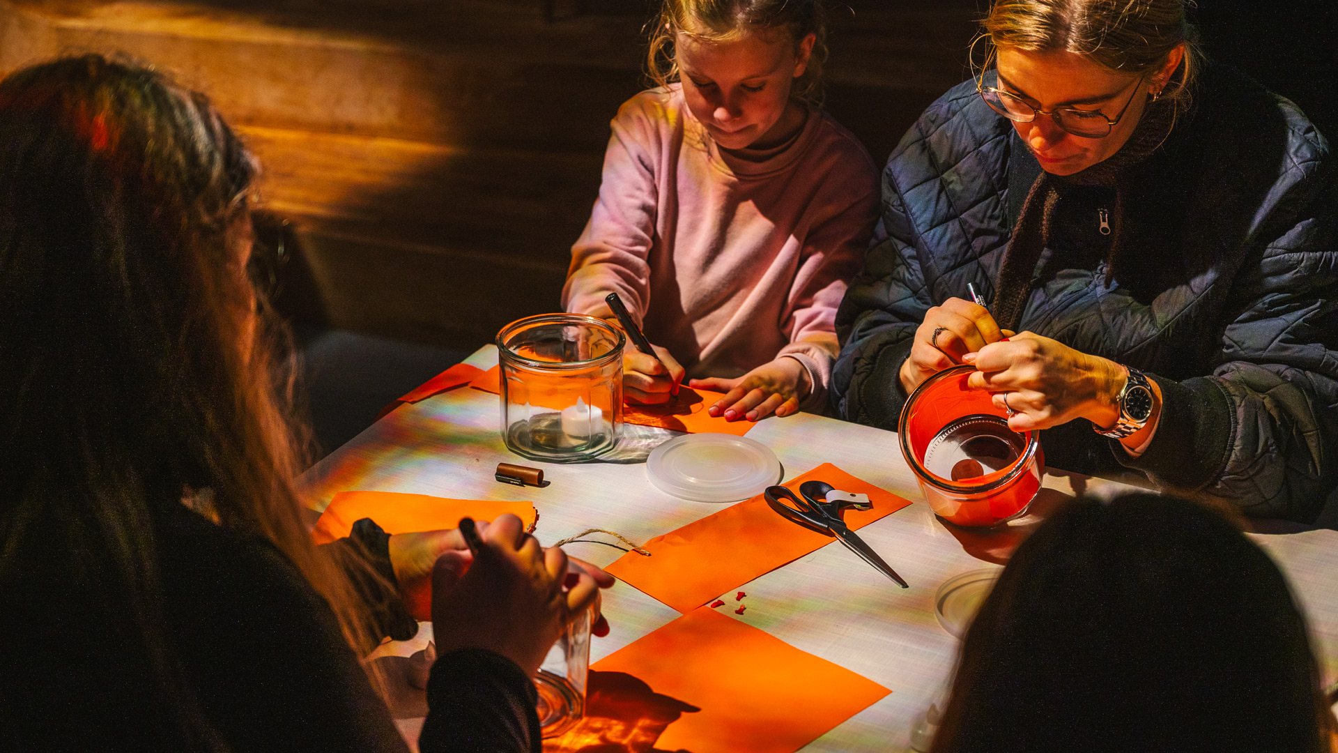 Children and adults making their own Halloween lanterns together.