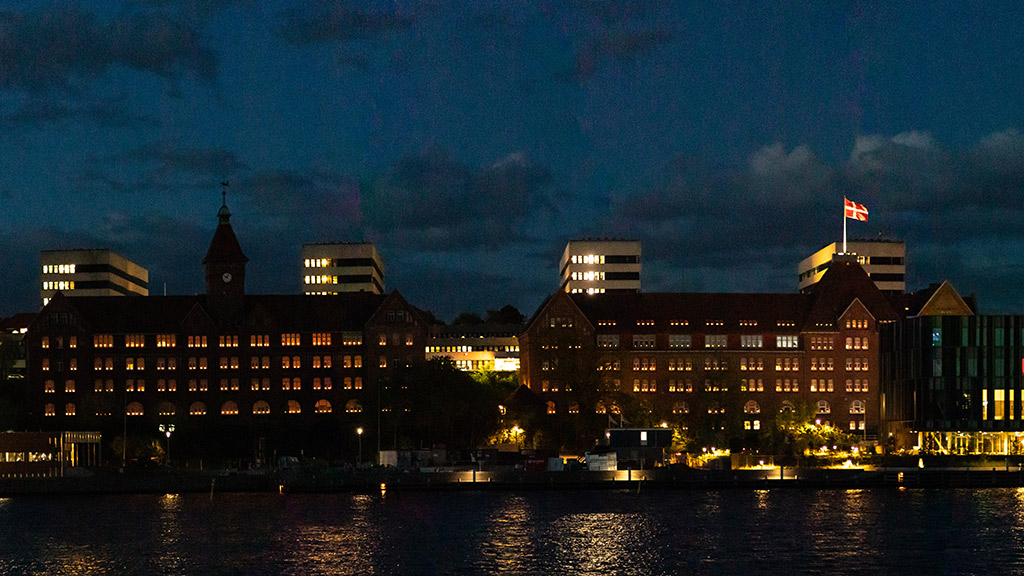 Sønderborg Kaserne på øen Als med lys i vinduerne og Dannebrog i det belyste flagtårn under fejring af Danmarks befrielse i 1945