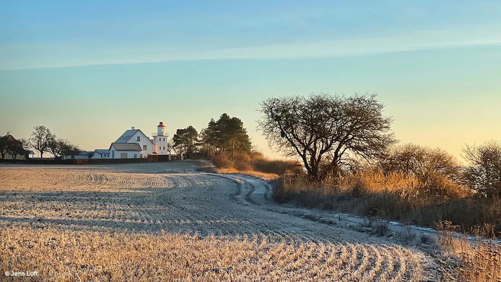 Snow in the fields in front of the lighthouse on Botofte Strand