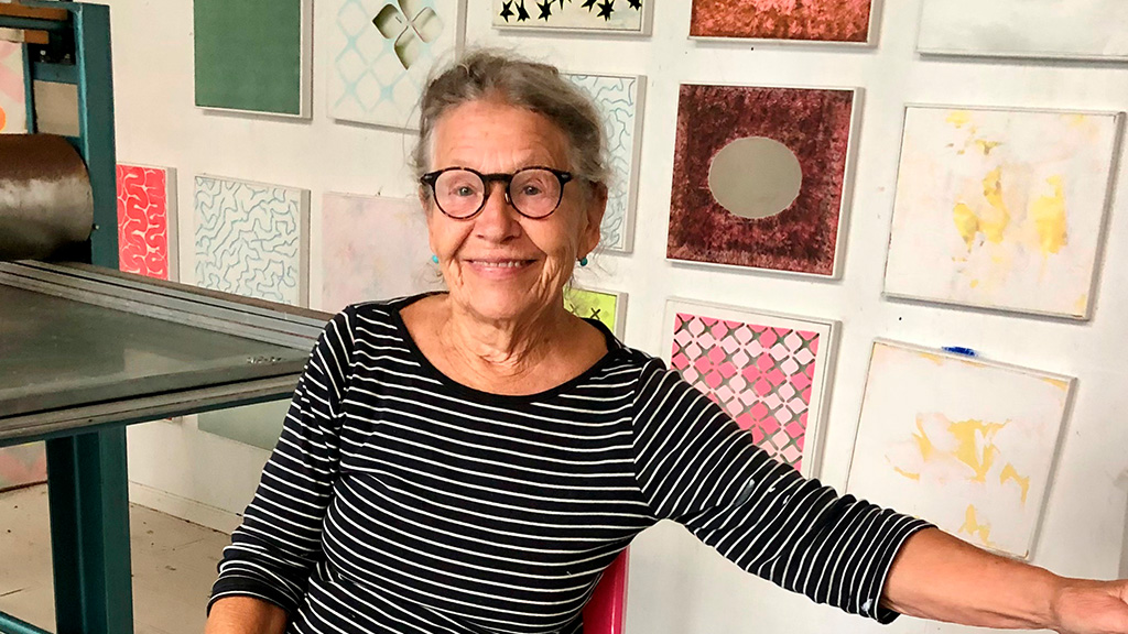 Britt Smelvær in front of the works on the wall