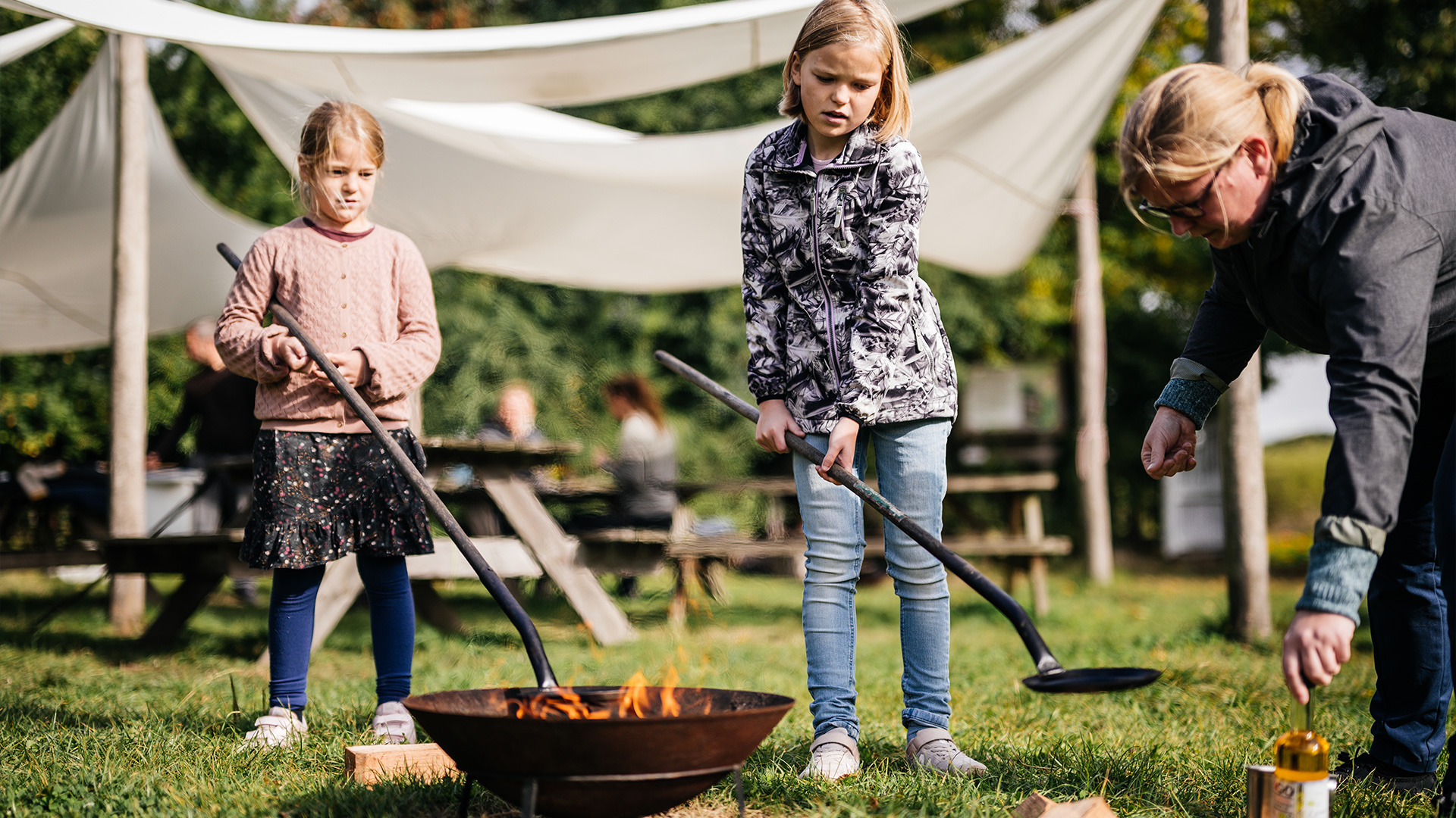 Children are making pancakes over a campfire at Skovsgaard Nature Destination