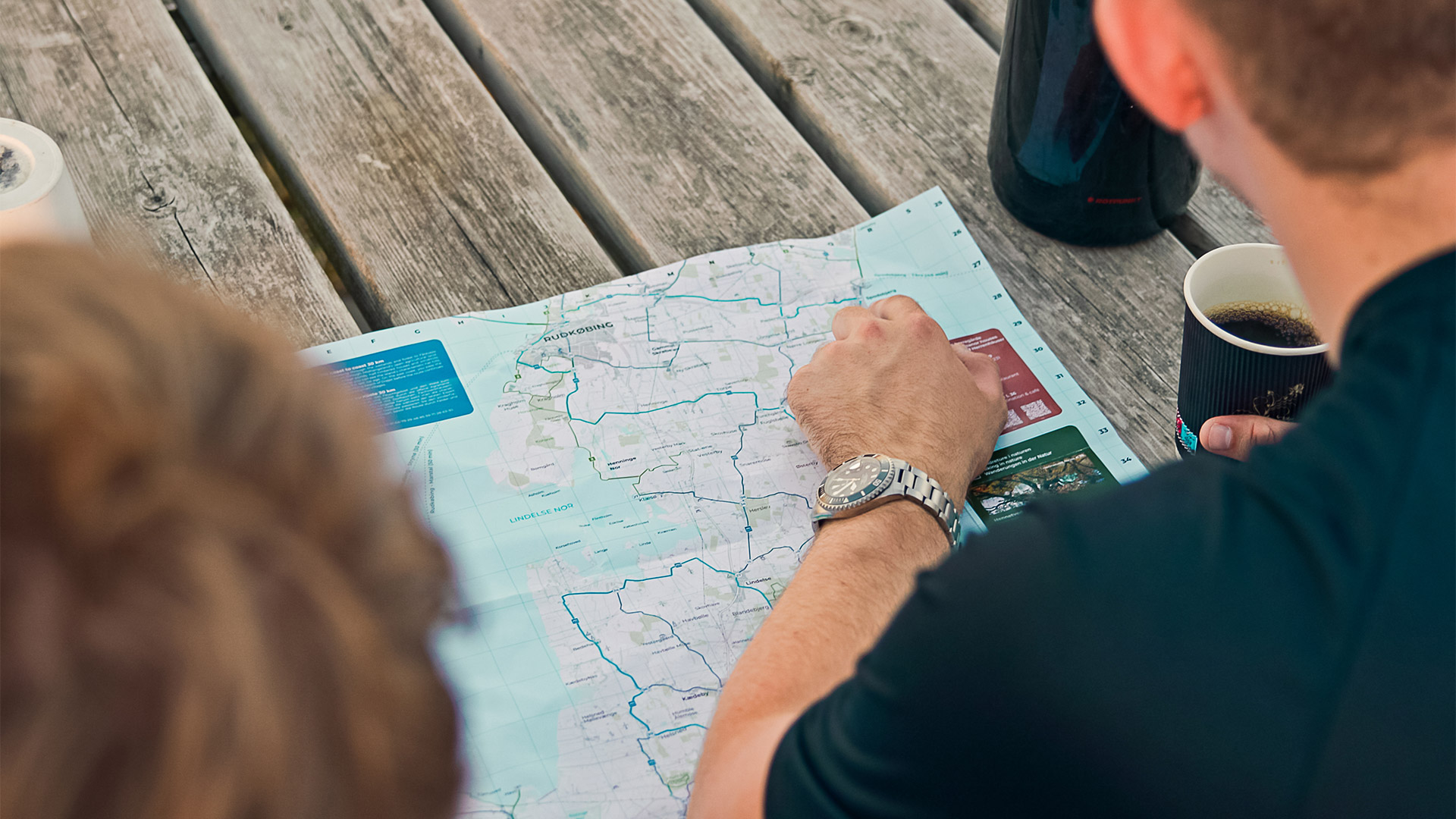 Cyclists plan their trip on Langeland using a cycling map