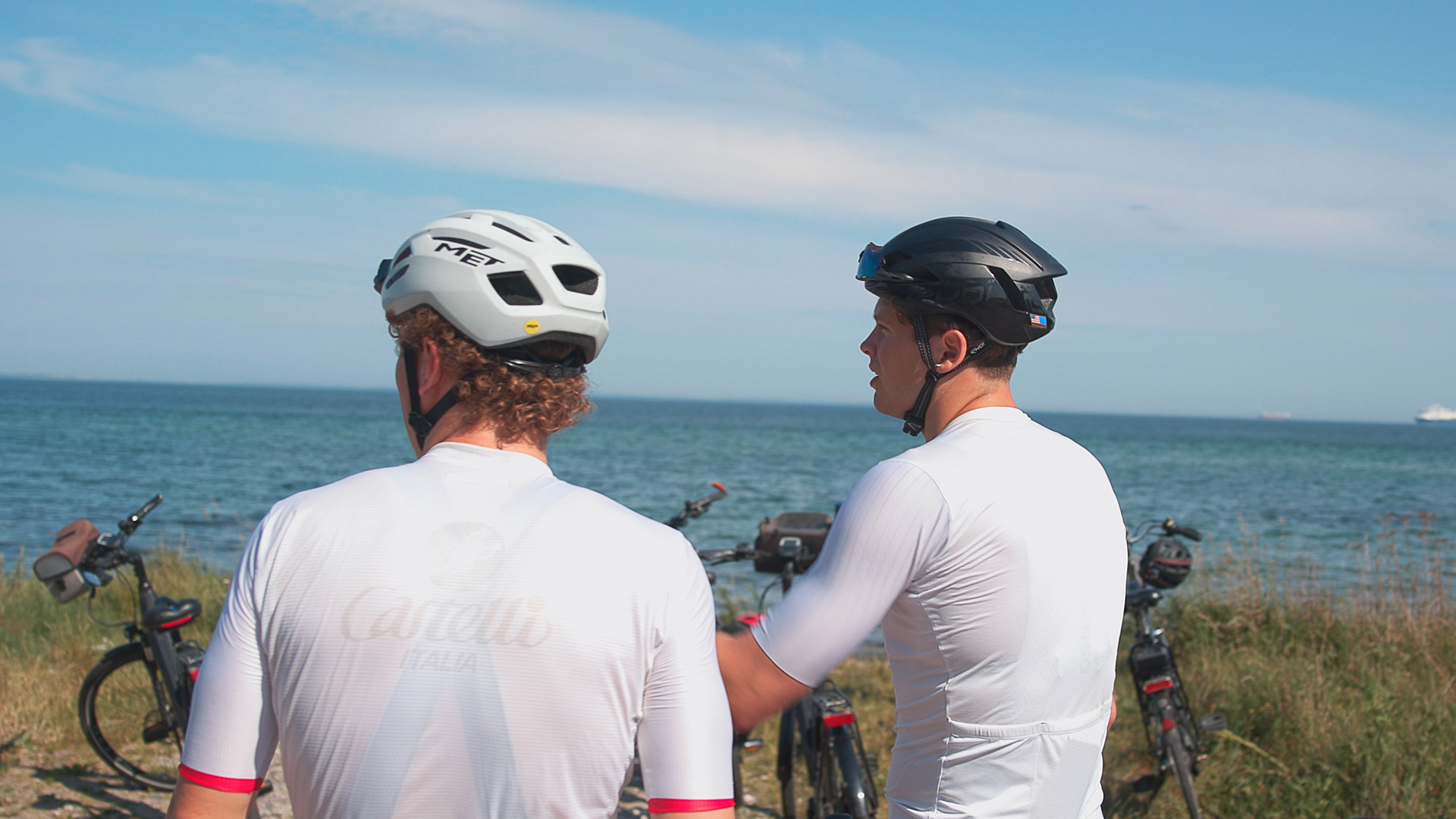 Two cyclists taking a break by the coast overlooking the Great Belt
