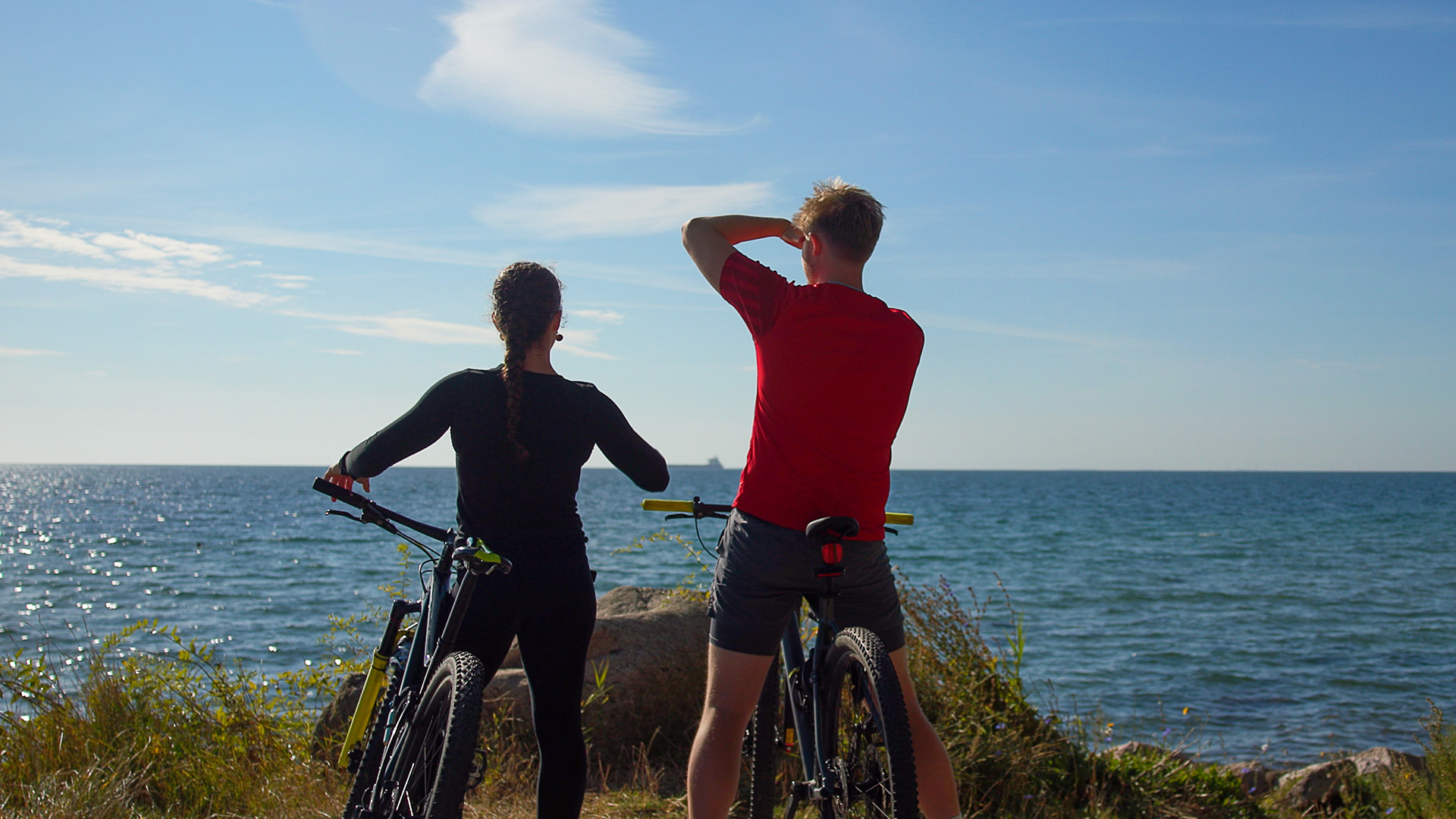 Two cyclists taking a break on the coast of northern Langeland overlooking the Great Belt