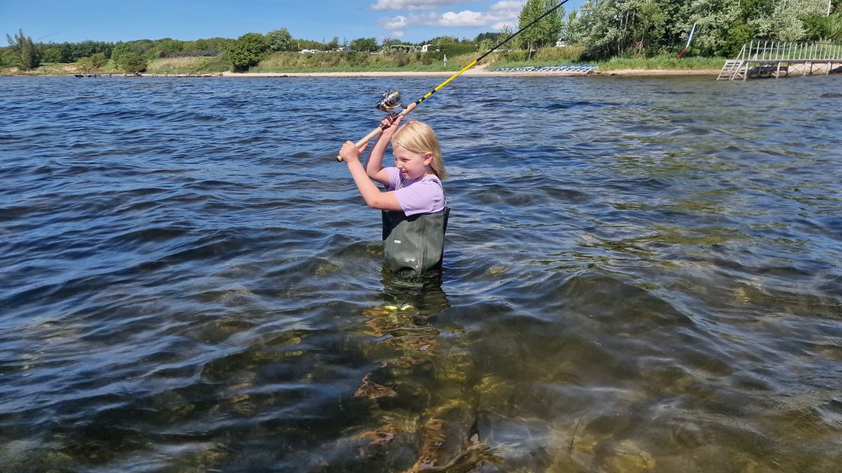 Lær at fiske - Pige i vaders med fiskestang