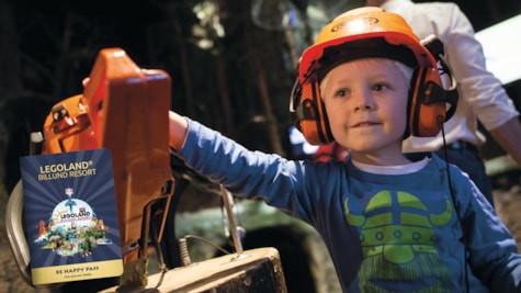 Boy with work equipment experiences an exhibition at the Økolariet