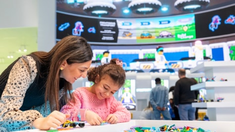 Mother and daughter are building cars in the blue zone of the LEGO® House