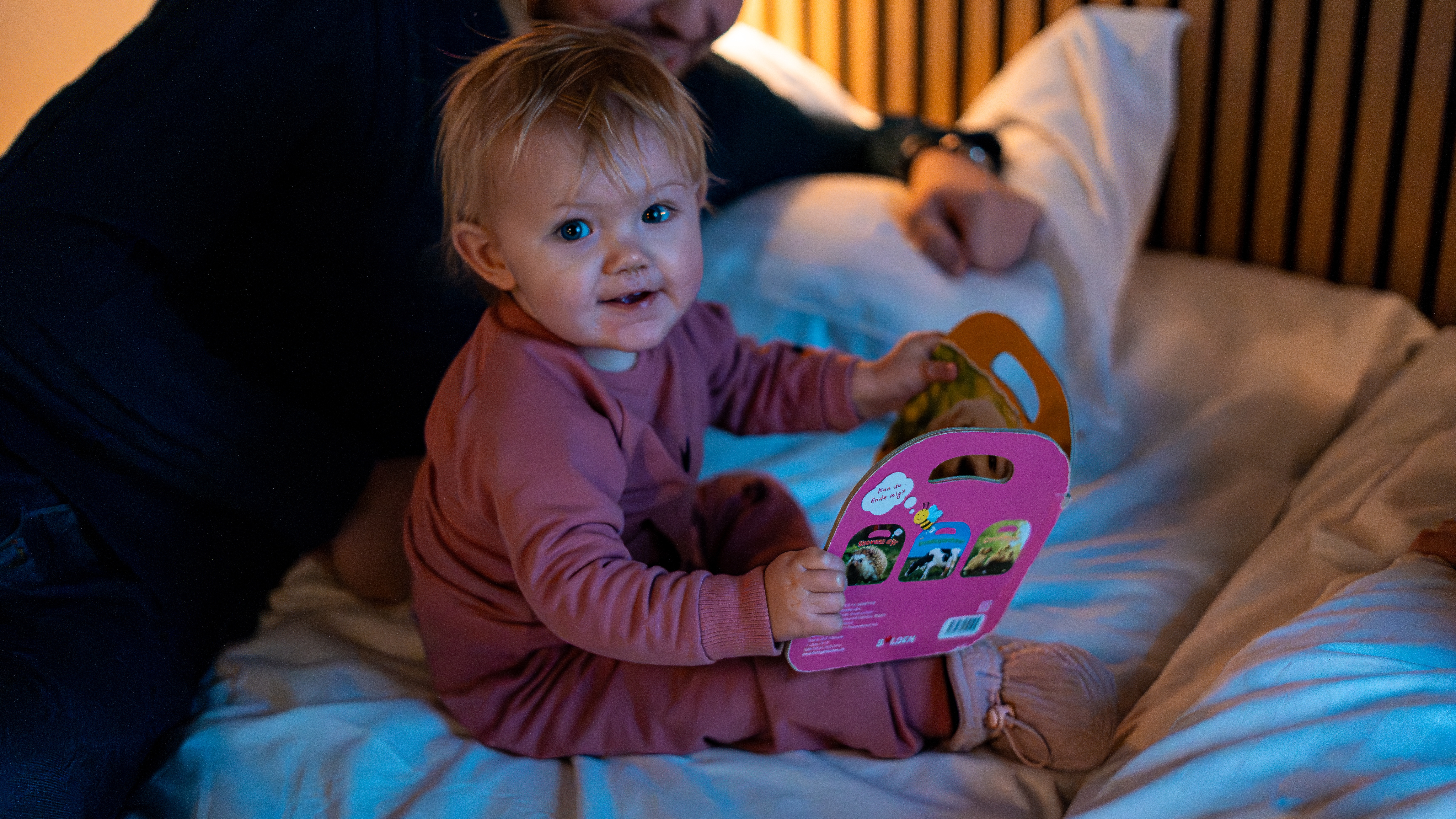 Child with book on bed