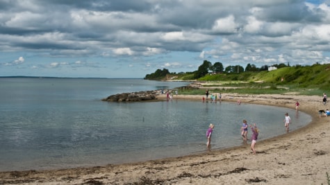 Sommerdag og børn nyder vandet ved Strandhuse strand