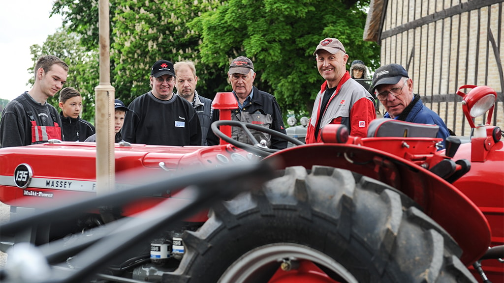 En gruppe mænd beundrer traktor hos Danmarks Ferguson Museum