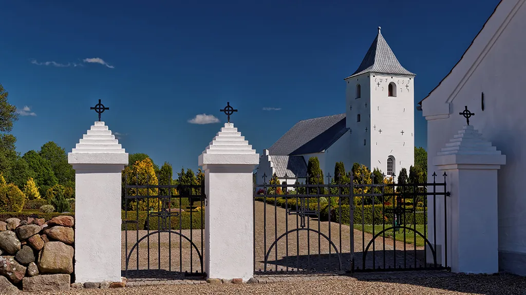Tamdrup Kirke set gennem porten ved indgangen til kirkegården