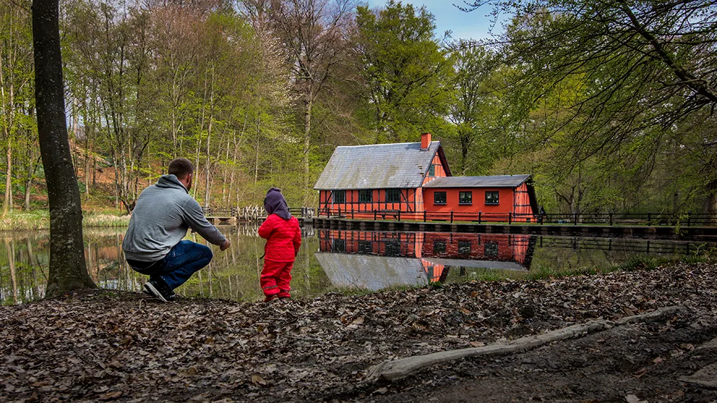 Far og datter sidder ved mølledammen ved Boller Vandmølle i Klokkedal Skov ved Horsens