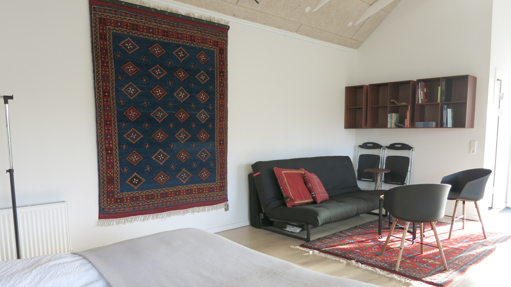 Living room in a room with a woven tapestry at the Gæstehus B&B in Haldrup