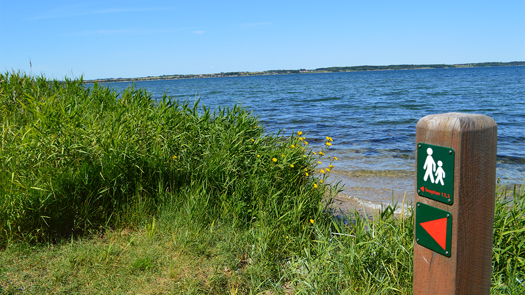 Route sign on a wooden post on the Coastal Path Snaptun-Juelsminde