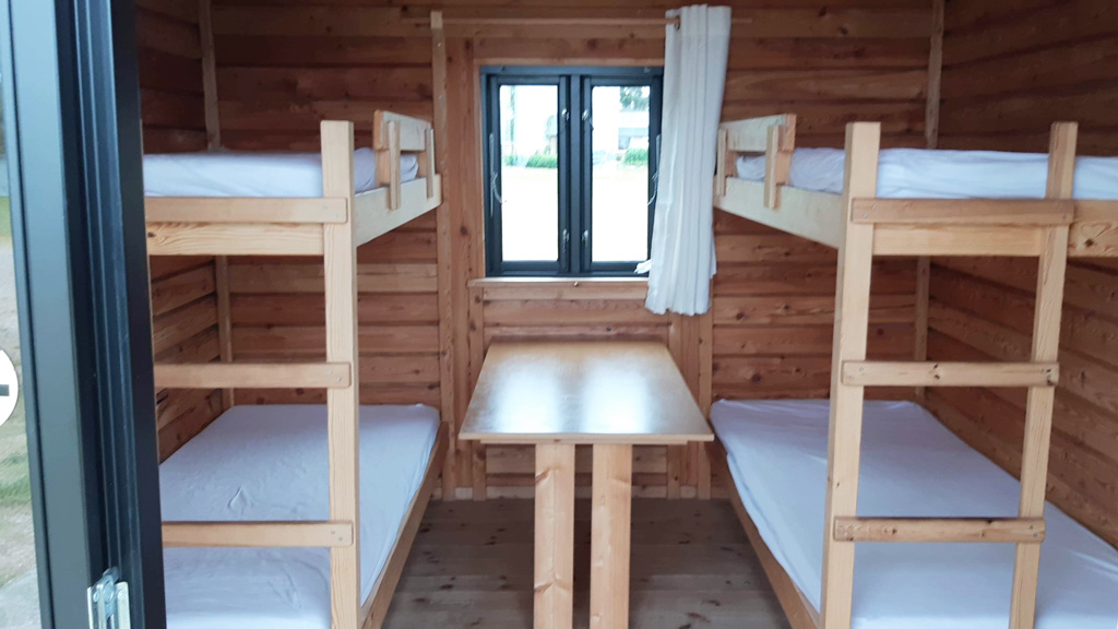 Sleeping and seating area in a cabin at the Tunø Campsite