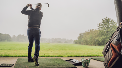 En golfspiller slår til bolden med sin kølle i Horsens Golfklub