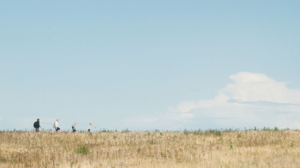 A family walks across the fields on Tunø on a treasure hunt