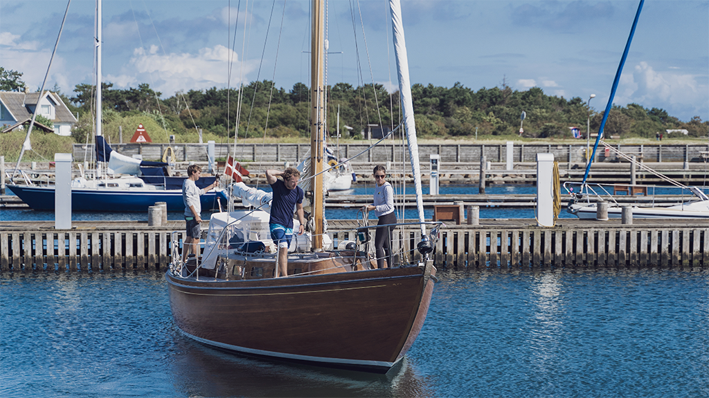 A boat is sailing out of Tunø Harbor.