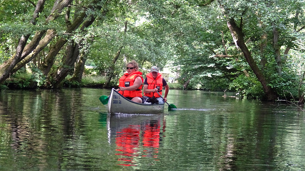 Woman and man in life vests on a canoe trip.