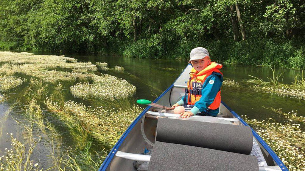 Boy in a life vest on a canoe trip.