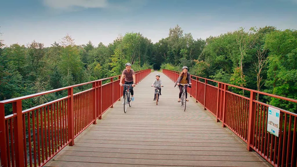 Far, mor og barn cykler på naturstien Horsens-Silkeborg på Den Genfundne Bro