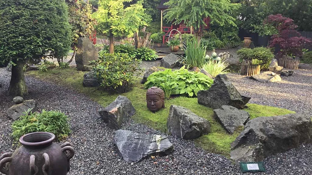 Buddha hoved og andre skulptur i sten have