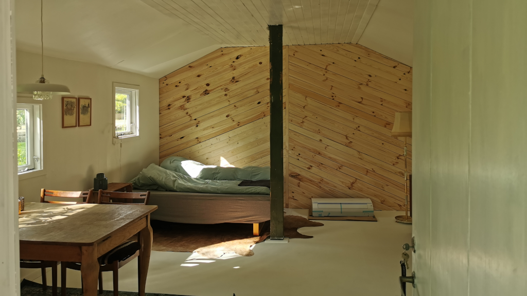 A bed and dining table in the annex at Holmely