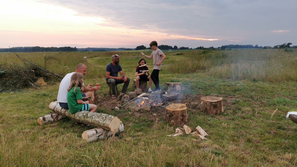 A family making twist bread over a campfire at Holmely
