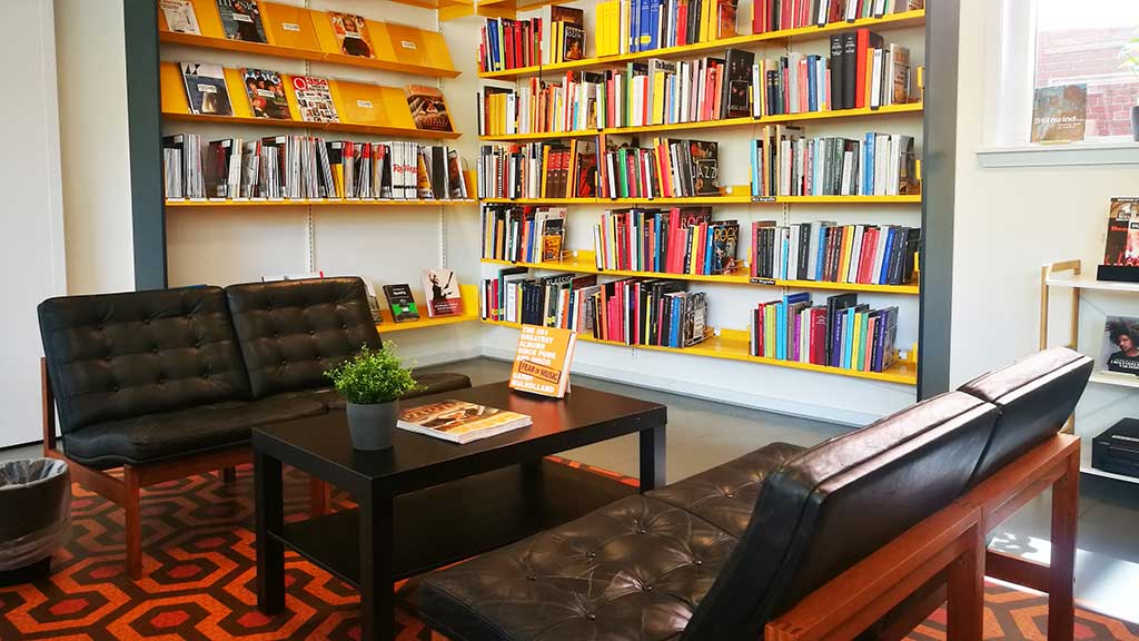 Sofas and a table in a corner at Horsens Library, with books about music in the background