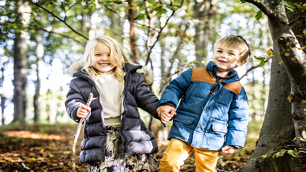 A girl and a boy are walking in the forest