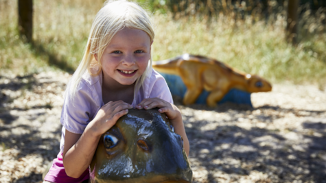 Pige og dinosaur i Givskud Zoo